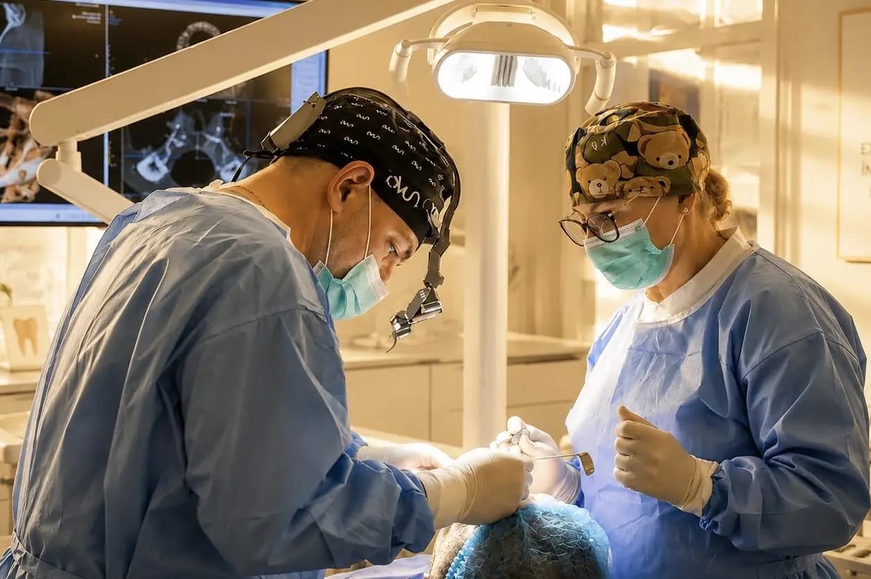 Medici ai clinicii în timpul unei intervenții de implantologie